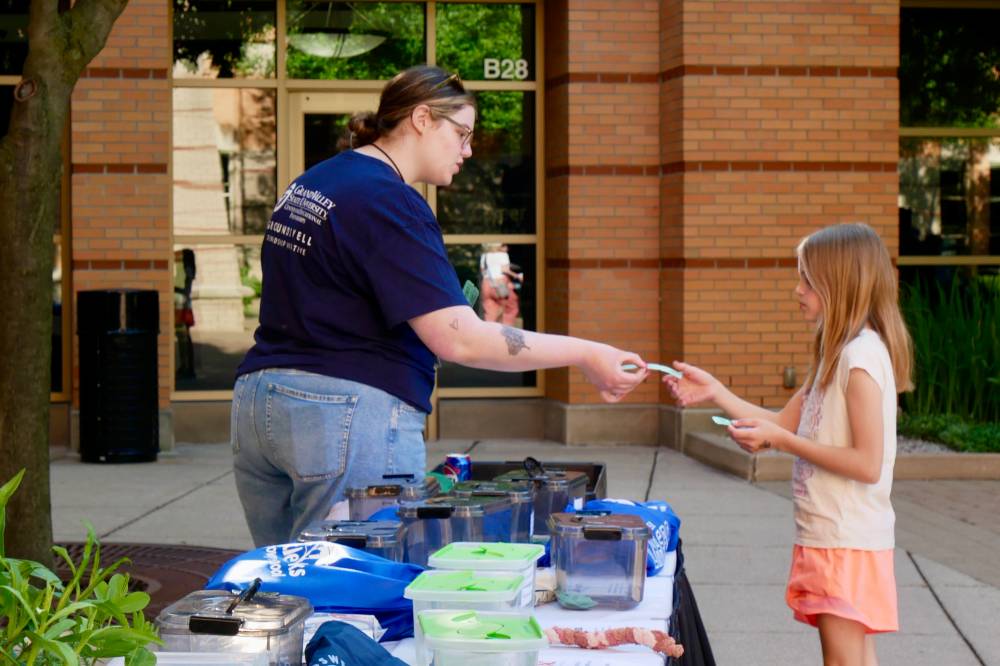Volunteer hands student a raffle ticket and the raffle table